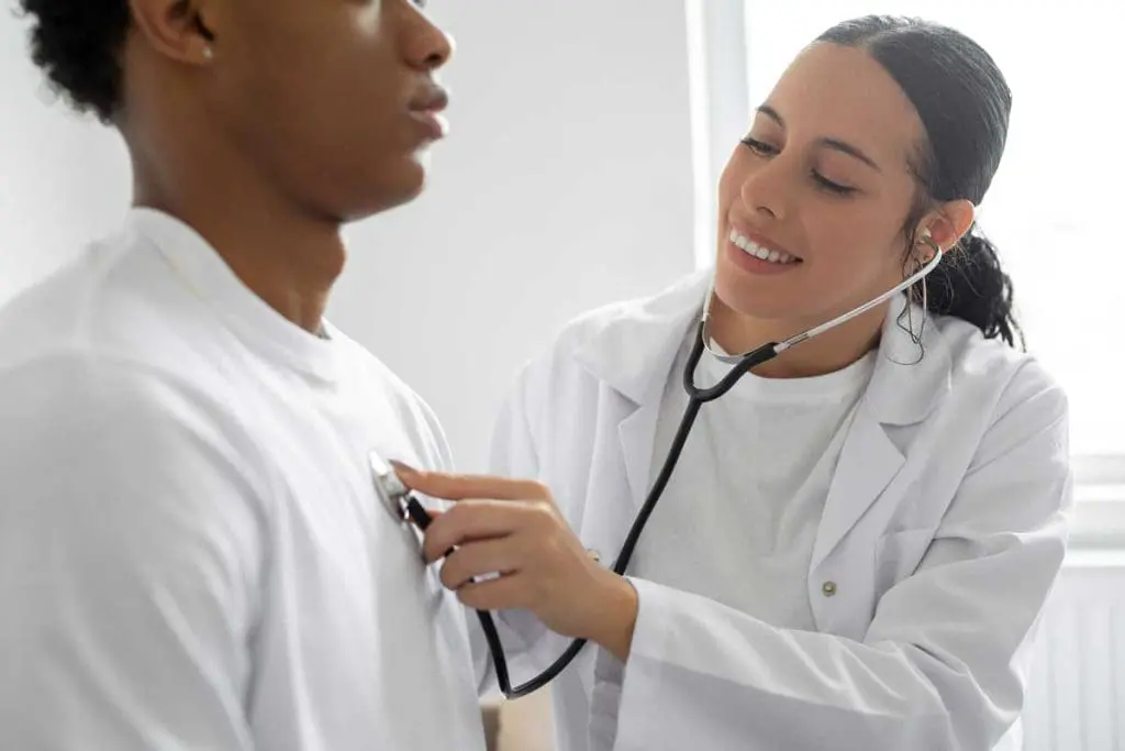 Doctor using a stethoscope to listen to a patient's heart, a routine procedure in OGUK physical assessments