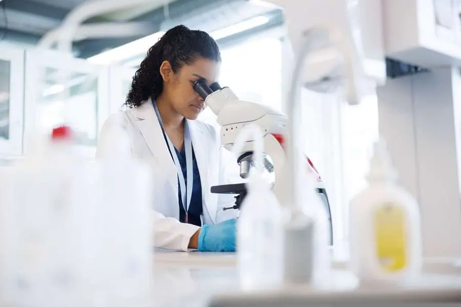 Scientist examining urine sample under a microscope for an HHS DOT mirror drug test