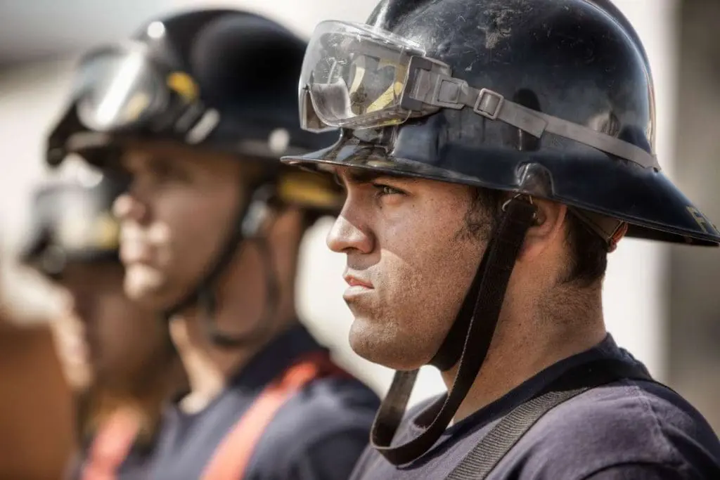 Focused firefighter with a black helmet, representing the personnel affected by nfpa 1582 medication disqualifications.