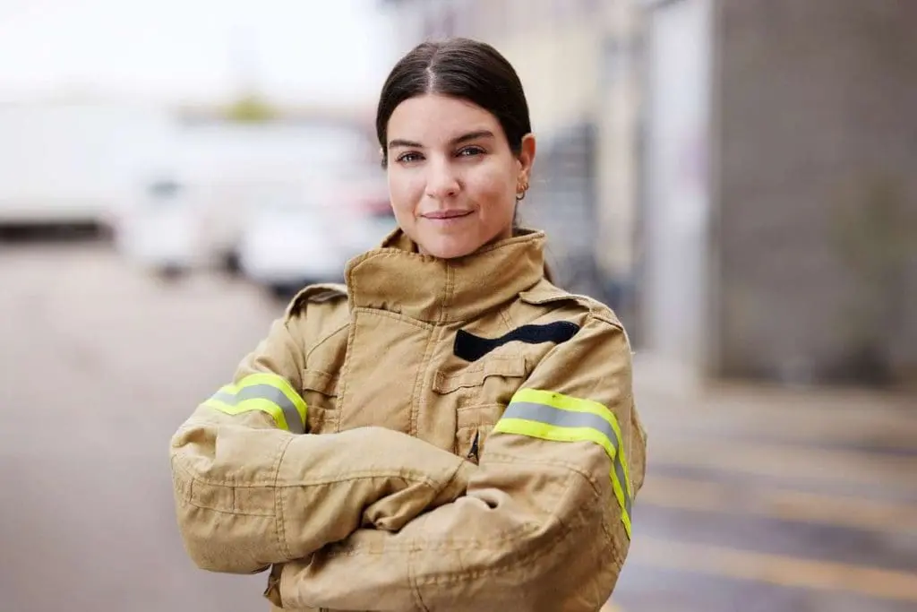 Determined female firefighter, exemplifying those in the field navigating nfpa 1582 medication disqualifications.