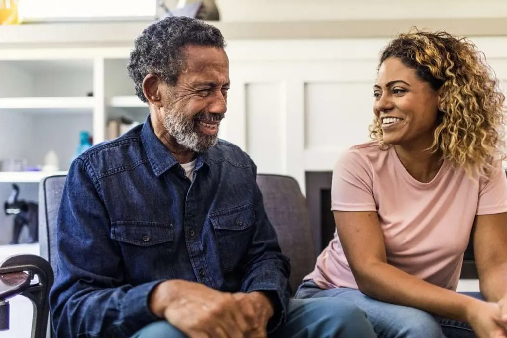 A young woman case manager discussing with an elderly man, highlighting the personalized approach of case management in social work.