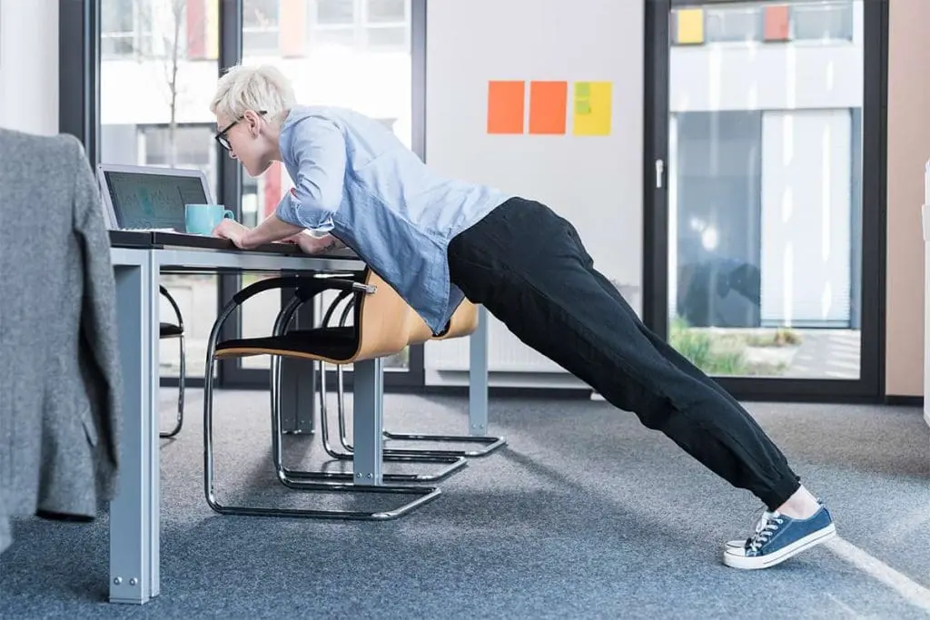 Person performing desk pushups in an office