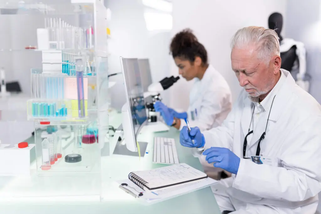Senior lab technician analyzing employee drug test samples with chromatography equipment