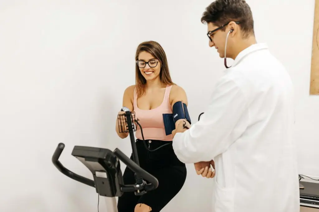 Healthcare worker taking a physical exam on a stationary bike