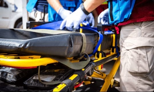 Emergency responders prepare a stretcher for patient transport, highlighting humanitarian efforts in critical situations.