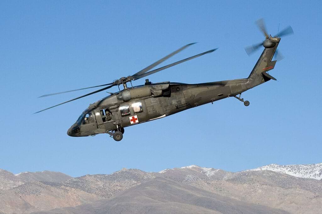 Military medical helicopter in flight, highlighting Acuity's expeditionary medicine services for U.S. military personnel.