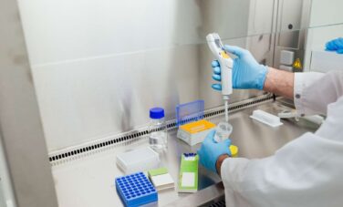 Scientist in blue gloves conducting an MRO drug test in a laboratory