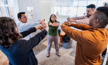 Group of office workers performing stretching exercises together