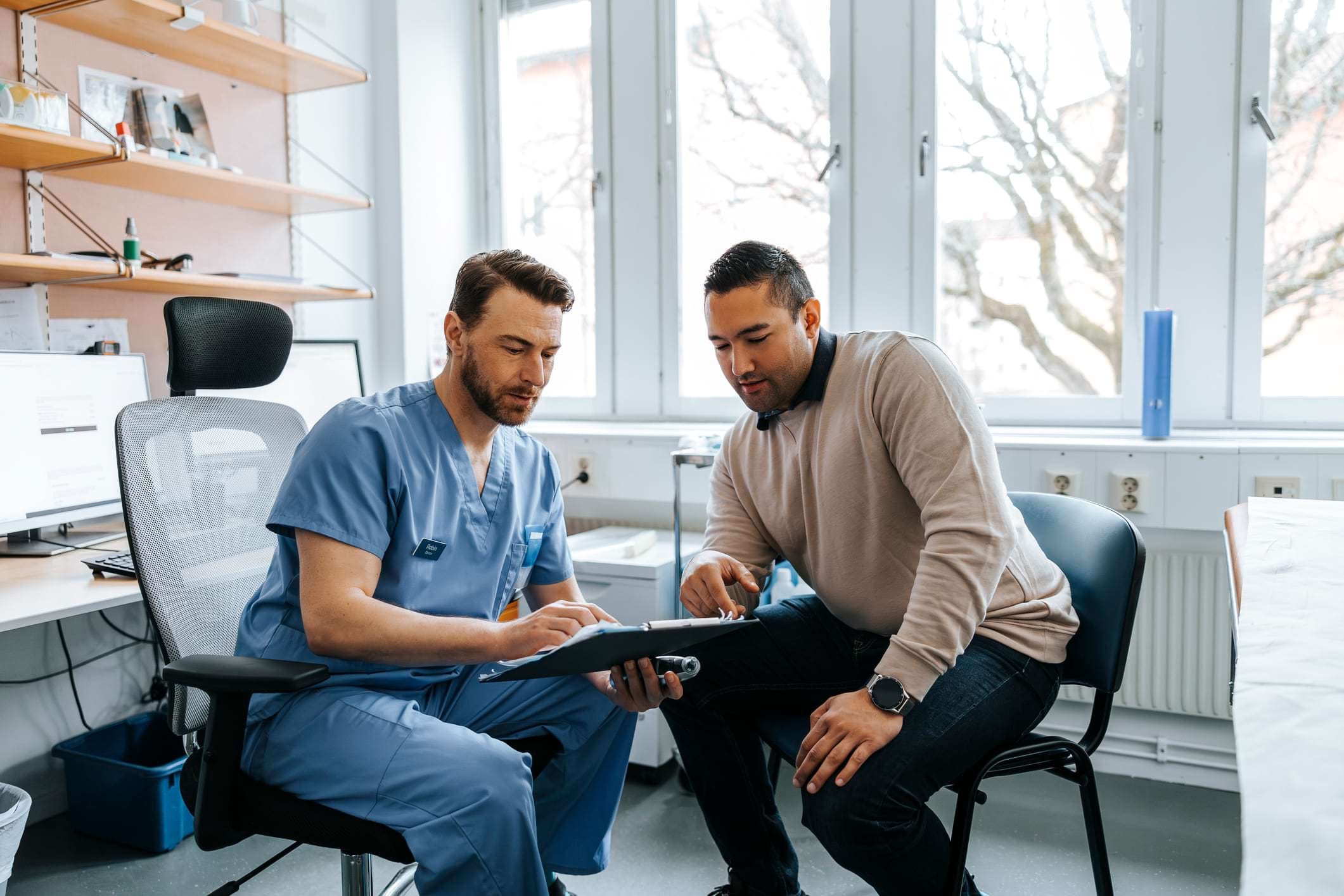 Clinician reviewing forms with a driver during a DOT physical consultation